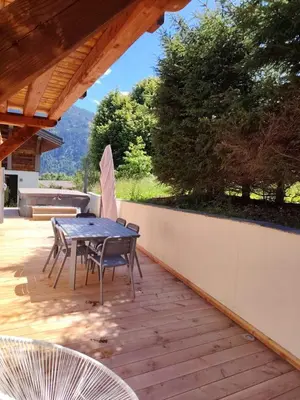 a patio with a table and chairs on a deck at Vielyterra - Chalet haut de gamme - Domaine du mont blanc in Saint-Gervais-les-Bains