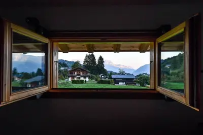 an open window with a view of a house at Vielyterra - Chalet haut de gamme - Domaine du mont blanc in Saint-Gervais-les-Bains