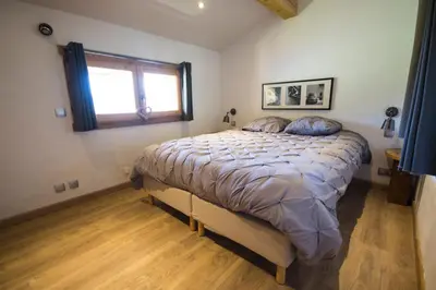 a bedroom with a large bed with a window at Vielyterra - Chalet haut de gamme - Domaine du mont blanc in Saint-Gervais-les-Bains