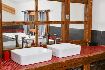 two white sinks on a red counter in a bathroom at Vielyterra - Chalet haut de gamme - Domaine du mont blanc in Saint-Gervais-les-Bains