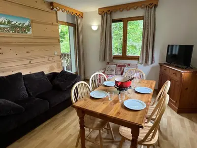 a living room with a wooden table and chairs at Confortable 2 pièces cabine à Samoëns avec wifi, parking et animaux admis - FR-1-629-105 in Samoëns