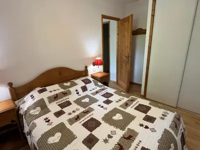 a bedroom with a bed with a quilt on it at Confortable 2 pièces cabine à Samoëns avec wifi, parking et animaux admis - FR-1-629-105 in Samoëns
