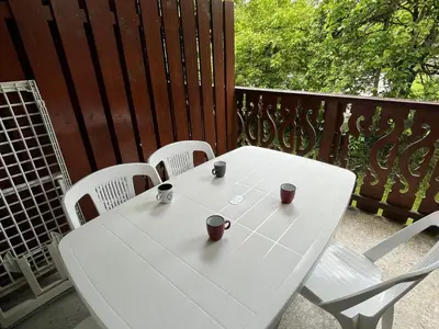 a white table and four chairs on a balcony at Confortable 2 pièces cabine à Samoëns avec wifi, parking et animaux admis - FR-1-629-105 in Samoëns