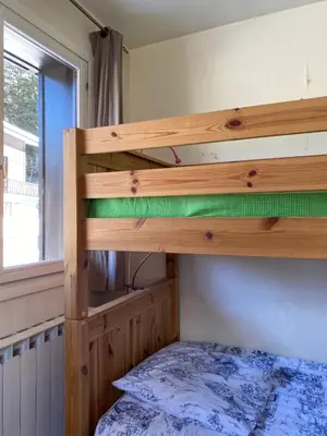 a bunk bed in a small room with a bed sidx sidx at Appartement cosy au pied du MtBlanc in Chamonix-Mont-Blanc