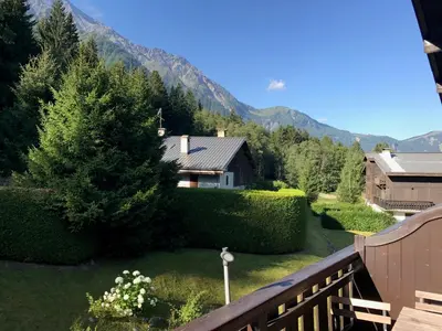 a view from a balcony of a house with a garden at Appartement cosy au pied du MtBlanc in Chamonix-Mont-Blanc