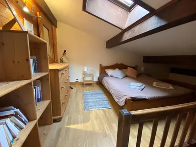 a bedroom with a bed and a wooden floor at Appartement cosy au pied du MtBlanc in Chamonix-Mont-Blanc