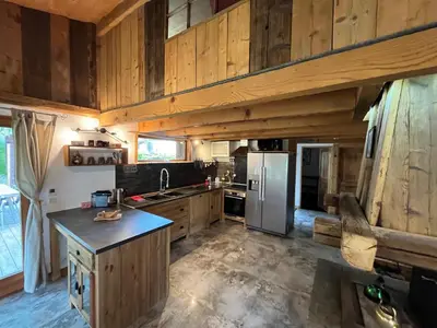 a kitchen with wooden cabinets and a stainless steel refrigerator at CHALET TOUDBIOLE haut de chalet in Les Houches