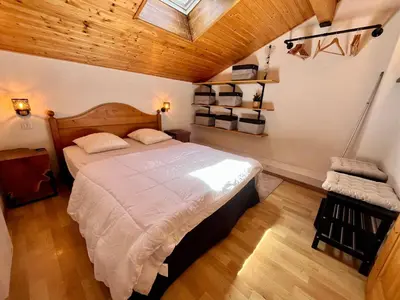 a bedroom with a large bed and a wooden ceiling at Appartement familial avec piscines à Samoëns - FR-1-624-103 in Samoëns