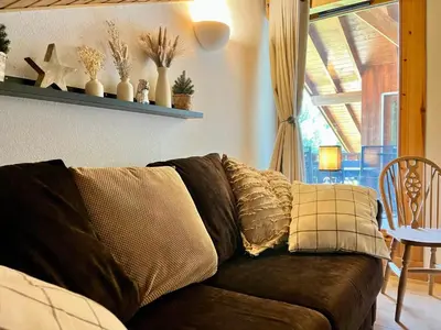 a brown couch with pillows in a living room at Appartement familial avec piscines à Samoëns - FR-1-624-103 in Samoëns