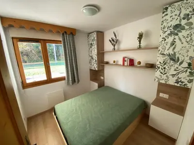 a small room with a green bed and a window at Appartement 3 pièces avec terrasse, animaux acceptés et parking - FR-1-629-106 in Samoëns
