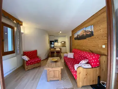 a living room with a red couch and a table at Appartement 3 pièces avec terrasse, animaux acceptés et parking - FR-1-629-106 in Samoëns
