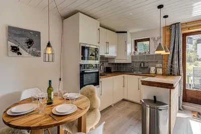 a kitchen with a wooden table and a dining room at Apartment Cry - Alpes Travel - Central Chamonix (sleeps 2-4) in Chamonix-Mont-Blanc