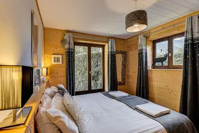 a bedroom with a large bed in front of a window at Apartment Cry - Alpes Travel - Central Chamonix (sleeps 2-4) in Chamonix-Mont-Blanc