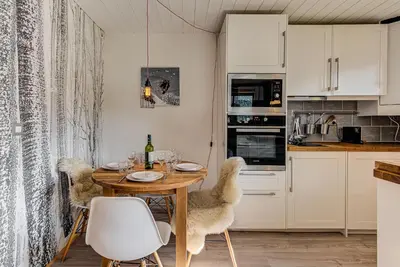 a kitchen and dining room with a wooden table and chairs at Apartment Cry - Alpes Travel - Central Chamonix (sleeps 2-4) in Chamonix-Mont-Blanc