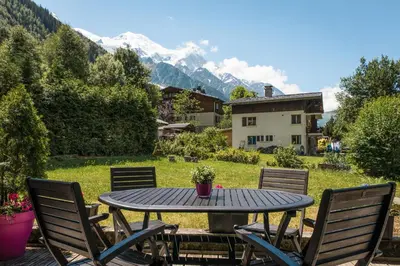 a table and chairs on a patio with mountains at Apartment Cry - Alpes Travel - Central Chamonix (sleeps 2-4) in Chamonix-Mont-Blanc