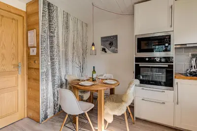 a dining room with a table and chairs and a kitchen at Apartment Cry - Alpes Travel - Central Chamonix (sleeps 2-4) in Chamonix-Mont-Blanc
