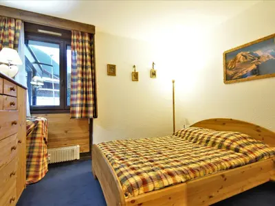 a bedroom with a wooden bed and a window at Apartment Arve 1 et 2-4 by Interhome in Chamonix-Mont-Blanc