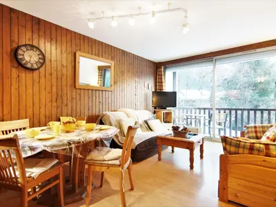 a living room with a table and a couch at Apartment Arve 1 et 2-4 by Interhome in Chamonix-Mont-Blanc