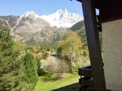 a train track with trees and mountains in the background at Apartment Alpen Roc by Interhome in Chamonix-Mont-Blanc