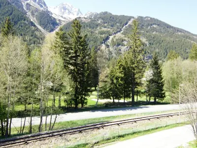 a train track with trees and mountains in the background at Apartment Alpen Roc by Interhome in Chamonix-Mont-Blanc
