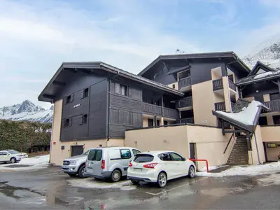 two cars parked in a parking lot in front of a building at Studio Les Arandellys by Interhome in Les Houches