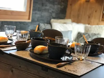 a table topped with cups and plates of bread at Charmant Mazot Le 1881 4 pers in Demi-Quartier