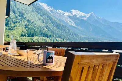 a wooden table with a coffee mug on top of it at Apartment Of 55 M With Balcony View Mont Blanc in Chamonix-Mont-Blanc