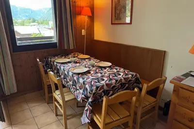 a dining room table with chairs and a table cloth at Apartment Of 55 M With Balcony View Mont Blanc in Chamonix-Mont-Blanc