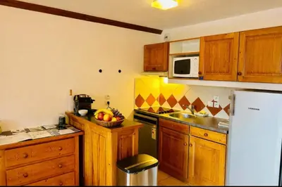 a kitchen with wooden cabinets and a white refrigerator at Apartment Of 55 M With Balcony View Mont Blanc in Chamonix-Mont-Blanc