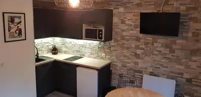 a kitchen with a sink and a microwave at Appartement Saint Gervais les Bains piscine et vue imprenable Mont Blanc in Saint-Gervais-les-Bains