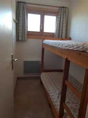 a room with two bunk beds and a window at Appartement Saint Gervais les Bains piscine et vue imprenable Mont Blanc in Saint-Gervais-les-Bains