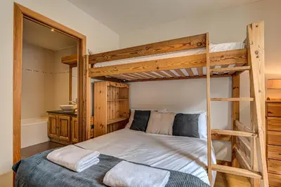 a bedroom with two bunk beds and a mirror at APARTMENT LE PARADIS 2 - ALPES TRAVEL - CENTRAL CHAMONIX (sleeps4-5) in Chamonix-Mont-Blanc