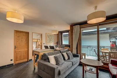 a living room with a couch and a table at APARTMENT LE PARADIS 2 - ALPES TRAVEL - CENTRAL CHAMONIX (sleeps4-5) in Chamonix-Mont-Blanc