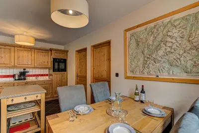a dining room with a table and a map on the wall at APARTMENT LE PARADIS 2 - ALPES TRAVEL - CENTRAL CHAMONIX (sleeps4-5) in Chamonix-Mont-Blanc