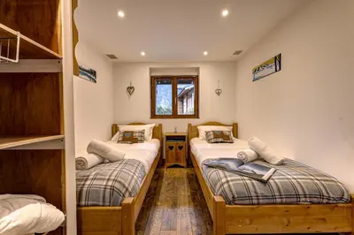 a room with two bunk beds and a window at Tiki Lodge - hot tub & sauna in Chamonix-Mont-Blanc