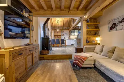 a living room with a couch and a kitchen at Tiki Lodge - hot tub & sauna in Chamonix-Mont-Blanc