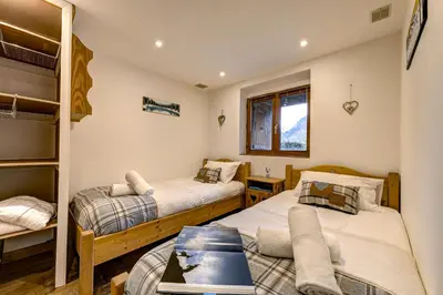 a bedroom with two beds and a couch at Tiki Lodge - hot tub & sauna in Chamonix-Mont-Blanc