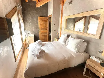 a bedroom with a bed with white sheets and a window at chalet Polar in Chamonix-Mont-Blanc