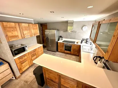 a kitchen with wooden cabinets and a stainless steel refrigerator at chalet Polar in Chamonix-Mont-Blanc