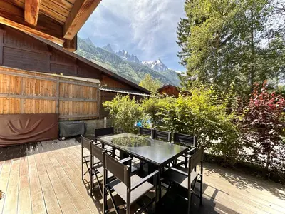 a patio with a table and chairs on a deck at chalet Polar in Chamonix-Mont-Blanc