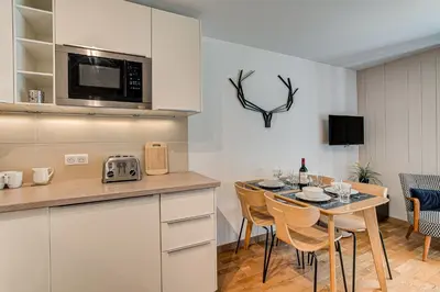 a kitchen and dining room with a table and chairs at Apartment Fermes du Montenvers B11 - Alpes Travel - Central Chamonix - sleeps 4 in Chamonix-Mont-Blanc