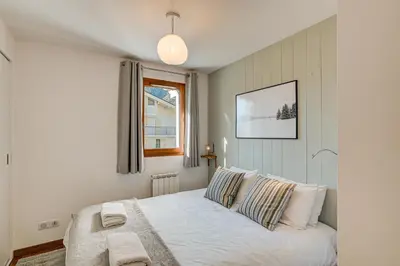 a bedroom with a bed with two pillows and a window at Apartment Fermes du Montenvers B11 - Alpes Travel - Central Chamonix - sleeps 4 in Chamonix-Mont-Blanc