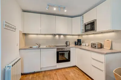 a kitchen with white cabinets and a sink at Apartment Fermes du Montenvers B11 - Alpes Travel - Central Chamonix - sleeps 4 in Chamonix-Mont-Blanc