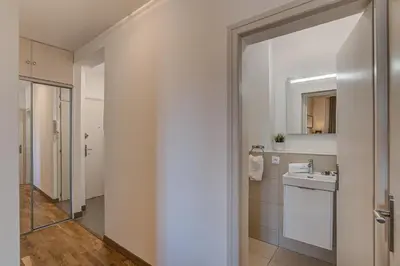 a white bathroom with a sink and a mirror at Apartment La Roseraie - Alpes Travel - Central Chamonix (sleeps 2-3) in Chamonix-Mont-Blanc