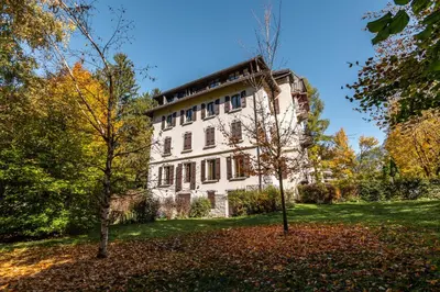 a large white building with trees in front of it at Apartment La Roseraie - Alpes Travel - Central Chamonix (sleeps 2-3) in Chamonix-Mont-Blanc