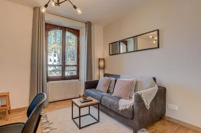 a living room with a couch and a table at Apartment La Roseraie - Alpes Travel - Central Chamonix (sleeps 2-3) in Chamonix-Mont-Blanc