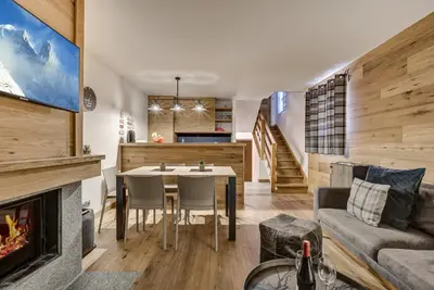 a living room with a table and a fireplace at Pic Janvier - Alpes Travel - Les Praz (sleeps 4-6) in Chamonix-Mont-Blanc