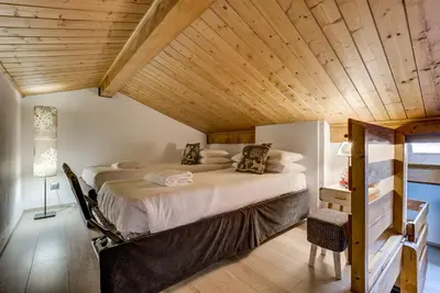 a large bed in a room with a wooden ceiling at Pic Janvier - Alpes Travel - Les Praz (sleeps 4-6) in Chamonix-Mont-Blanc