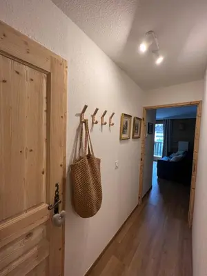 a hallway with a door to a room with a purse on the wall at Mont Blanc 25, vue Mont blanc, balcon, parking in Chamonix-Mont-Blanc
