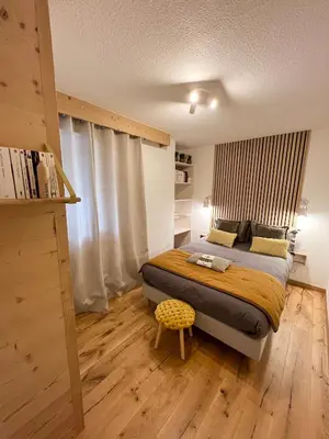 a bedroom with a bed and a wooden floor at Mont Blanc 25, vue Mont blanc, balcon, parking in Chamonix-Mont-Blanc